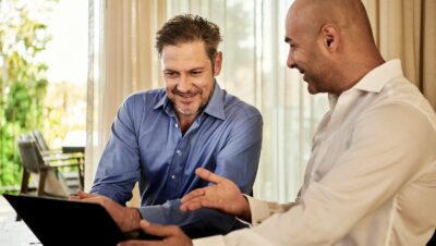 man in blue dress shirt beside man in white dress shirt