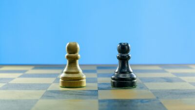 a black and a white chess piece on a checkered board